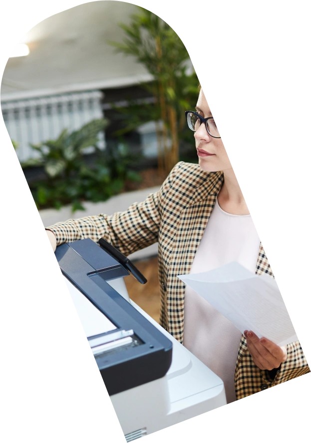 Vrouw haalt een afdruk op uit een printer.