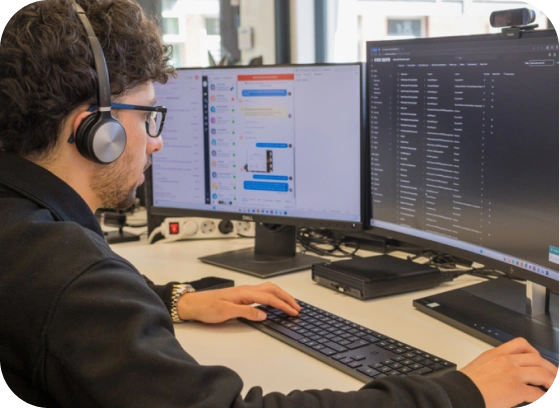 Man gericht op computerschermen in een centrum voor beveiligingsactiviteiten, dat staat voor 24/7 bewaking van cyberbeveiliging