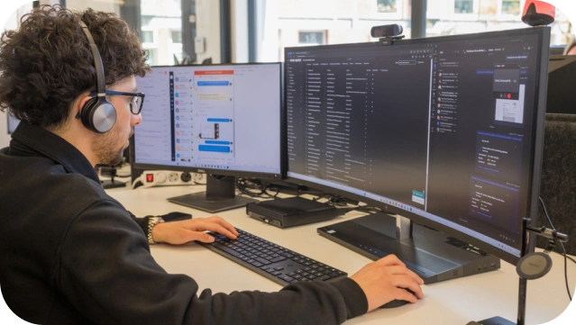 man gericht op computerschermen, staat voor proactieve cyberbeveiligingsbewaking voor uw bedrijf.