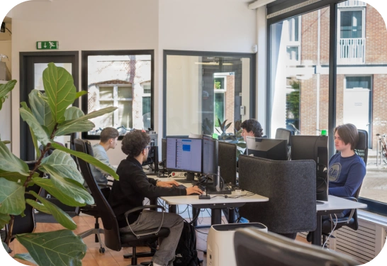 Man gericht op computerschermen in een centrum voor beveiligingsactiviteiten, dat staat voor 24/7 bewaking van cyberbeveiliging.